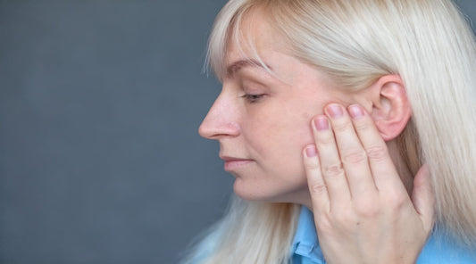 A women holding her face to her ear