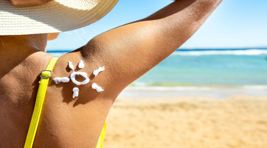 Woman relaxing on the beach, her skin glowing with a layer of natural sunscreen, highlighting the shift towards eco-friendly sun protection choices.