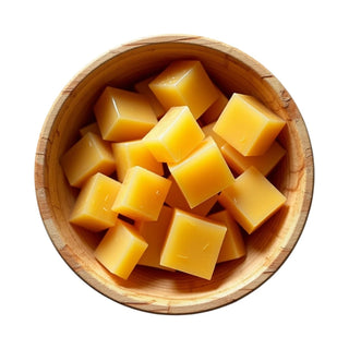 Wooden bowl of golden beeswax pieces