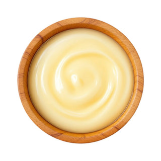 Wooden bowl of smooth cream-colored colostrum